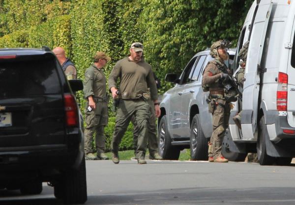 Law enforcement agents outside Diddy's mansion. 