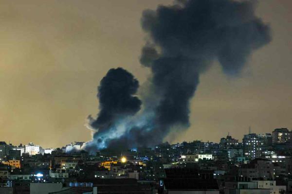 A plume of smoke rises above buildings in Gaza City during an Israeli air strike, on October 8, 2023. The death toll surged to almost 1,000 since Palestinian militant group Hamas launched its massive surprise attack on Israel with a barrage of rockets and a massive ground assault.