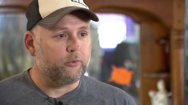 Police Chief Travis Bryant talks to camera with baseball cap on