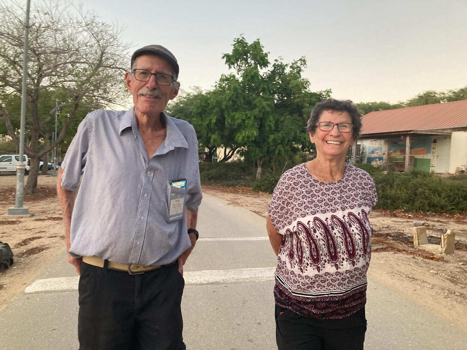 Sharone's parents standing next to each other, smiling, in the street