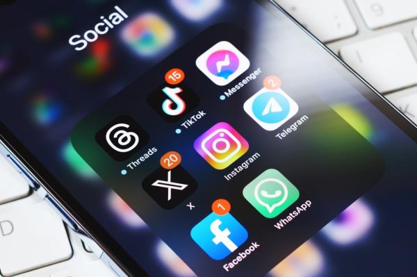 Smartphone screen displaying the new Elon Musk's Twitter X app surrounded by various other social media apps