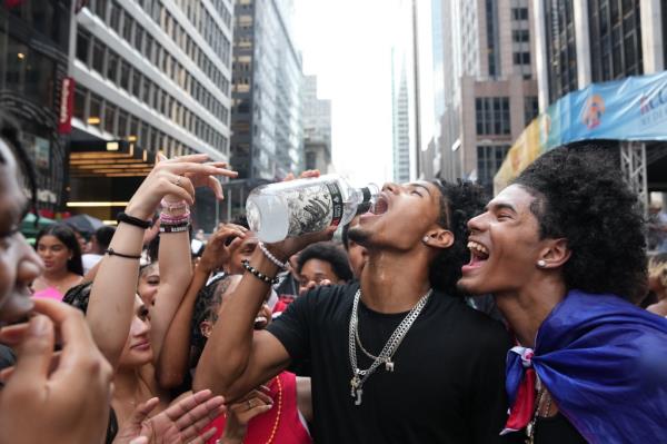 A man drinking in the street.
