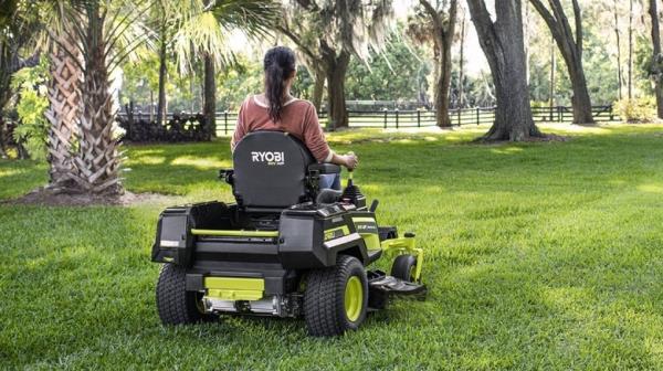 woman riding a zero turn on lawn