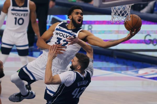 Minnesota Timberwolves center Karl-Anthony Towns (32) drives to the basket over Dallas Mavericks forward Maxi Kleber (42) during the second half in Game 4 of the NBA basketball Western Co<em></em>nference finals, Tuesday, May 28, 2024, in Dallas.