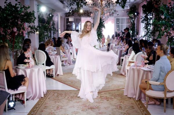 A model in a white dress walking down the runway at the S/S 2025 LoveShackFancy fashion show during New York Fashion Week
