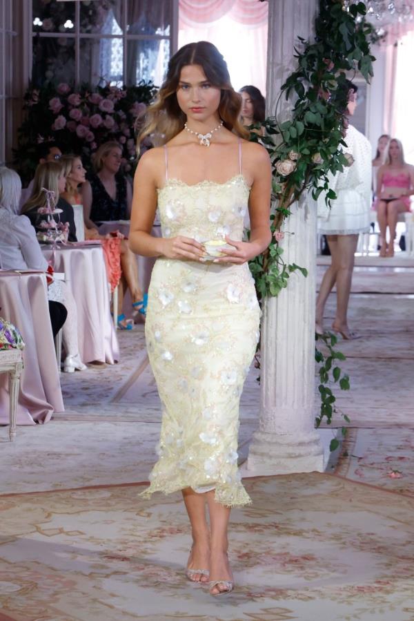 A model walking the runway in a white dress at the LoveShackFancy S/S 2025 New York Fashion Week show