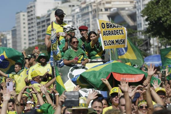 People in Brazil protesting holding sign in support of Elon Musk