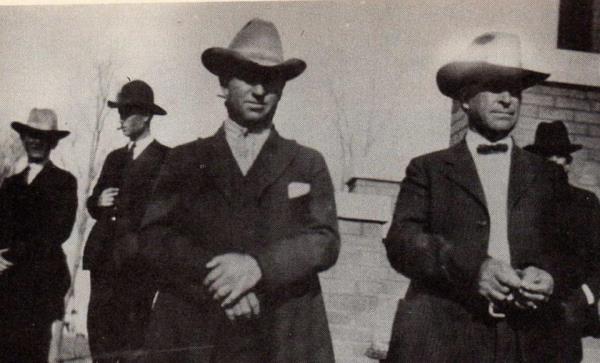 Milton Good, left, and Tom Ross on trial, in handcuffs.