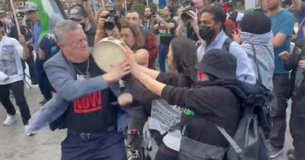 An anti-Israel protester smacks Richman with a tambourine during the protests in NYC on Oct. 7, 2024.