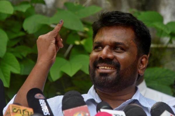 Anura Kumara Dissanayake, the presidential candidate from National People's Power, shows his ink-marked finger after casting his vote at a polling station in Colombo.