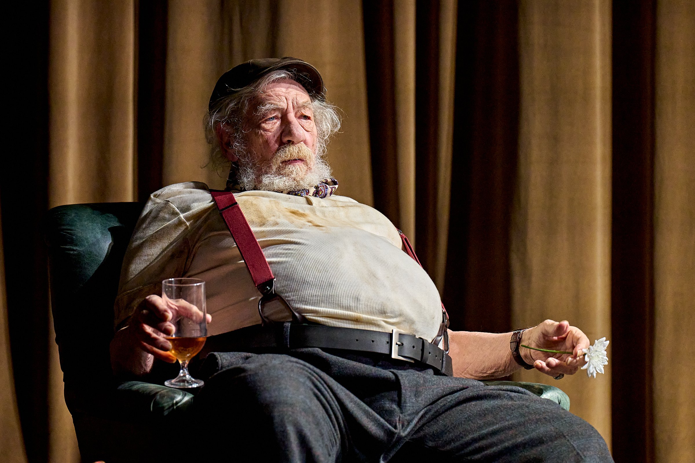 Sir Ian McKellen sits on stage as Falstaff in Player Kings