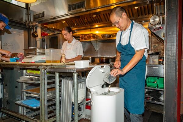 Jeremiah Stone, Chef and Owner of Bar Contra, with a Mill food recycler in the Bar Contra kitchen