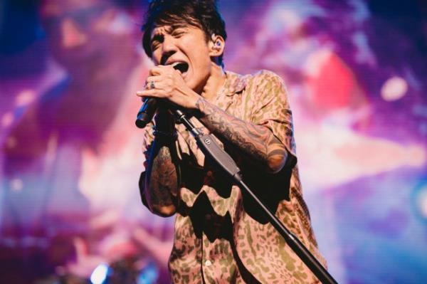 Journey's Arnel Pineda singing into a microphone 