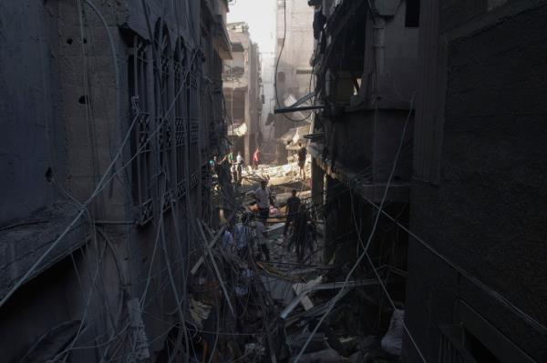 Palestinians inspect the rubble of buildings hit by an Israeli airstrike at Al Shati Refugee Camp.
