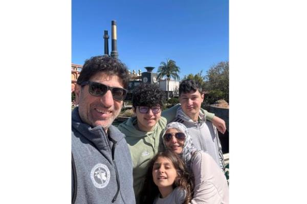 Dr. Ammar Ghanem, an ICU specialist from Detroit volunteering with the Syrian American Medical Society at one of Gaza's last functioning hospitals, left, poses with his family in Orlando, Fla., late Feb. 2024. A group of 35 foreign doctors on a volunteer mission to help at the hospital, including 22 Americans, have been trapped in Gaza by Israel's seizure of the Rafah crossing into Egypt.