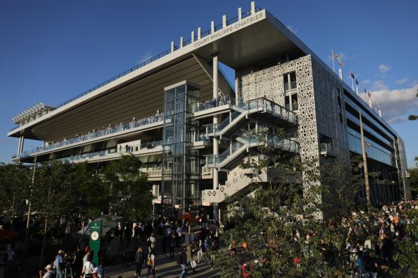 Fans arriving at Court Philippe Chatrier for a night session of the 2022 French Open Tennis Tournament under the late evening sun in Paris, France.