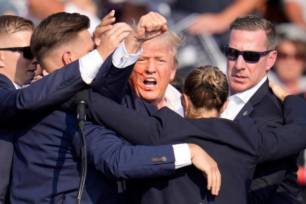 Former President Donald Trump exiting the stage with help from Secret Service agents at a 2024 campaign event in Butler, PA