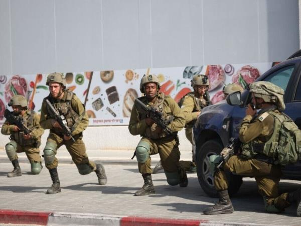 Israeli soldiers deploy in an area where civilians were killed in the southern city of Sderot on October 7, 2023.
