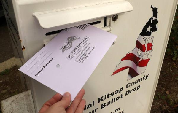 A ballot is dropped into the box at the Norm Dicks Government Center in Bremerton
