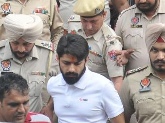 Gangster Lawrence Bishnoi comes out of the Amritsar court complex in October 2022 amid heavy police security. His gang was involved in the killing of singer Sidhu Moose Wala, and more recently politician Baba Siddique. (Getty Images)