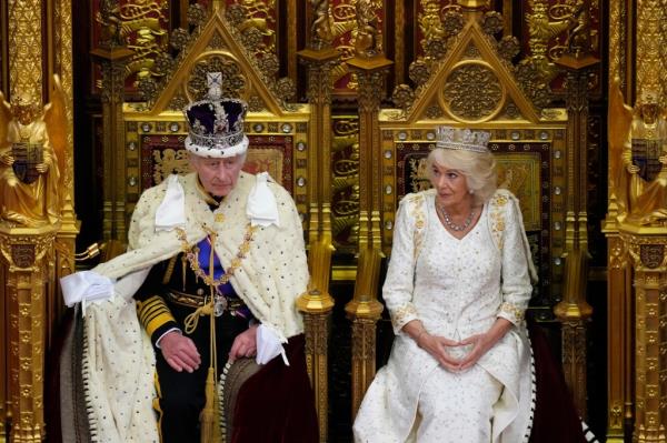 Britain's King Charles III sits besides Queen Camilla