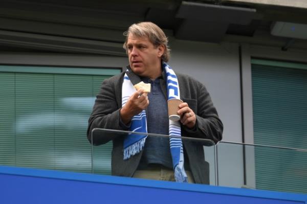 Todd Boehly pictured watching a Chelsea match while eating a snack and holding a coffee cup