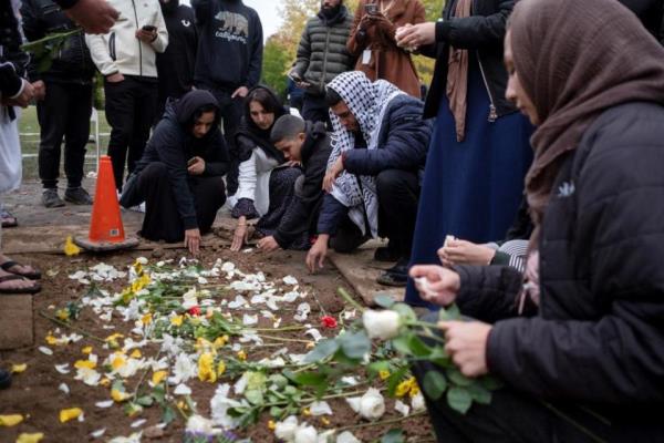 Mourners place flowers at the grave of Wadea Al-Fayoume at Parkholm Cemetery wher<em></em>e the burial took place in LaGrange, Illinois, on 16 October.