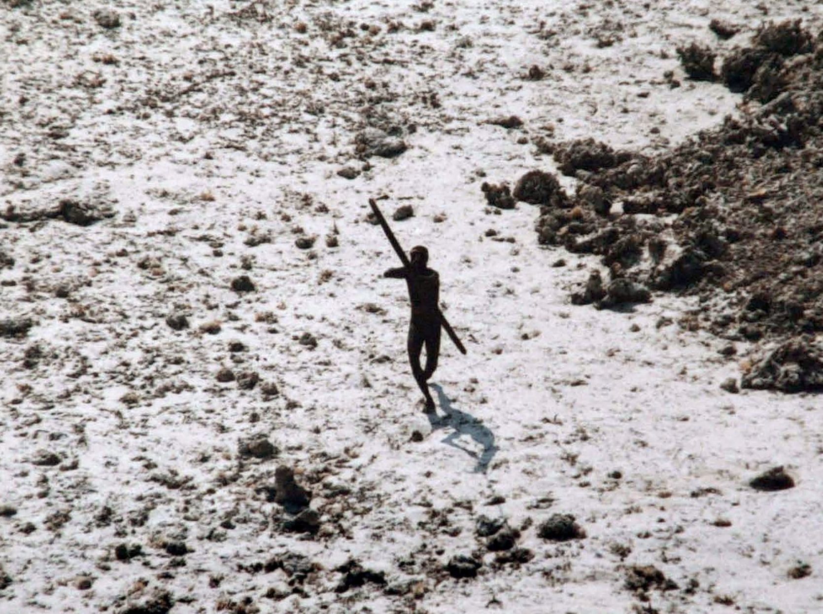 A man with the Sentinelese tribe aims his bow and arrow at an Indian Coast Guard helicopter as it flies over North Sentinel Island in the wake of the 2004 Indian Ocean tsunami