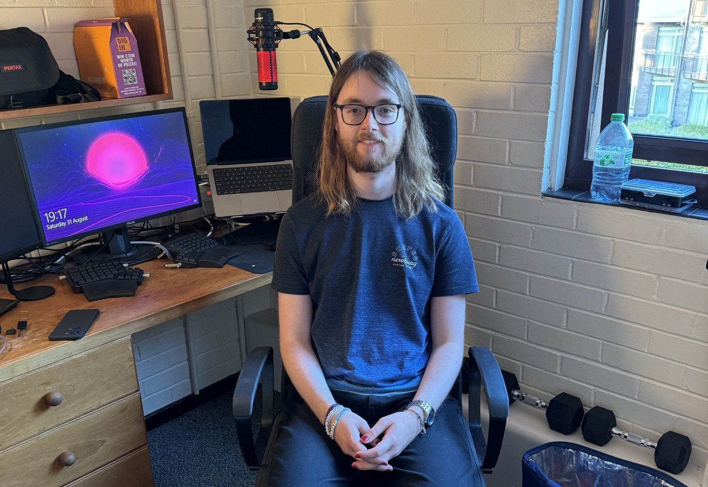 Julie's son, James, sitting in front of a desk, facing towards the camera