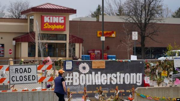 FILE - Tributes cover the temporary fence around the King Soopers grocery store in which 10 people died in a mass shooting in late March in Boulder, Colorado, April 23, 2021.