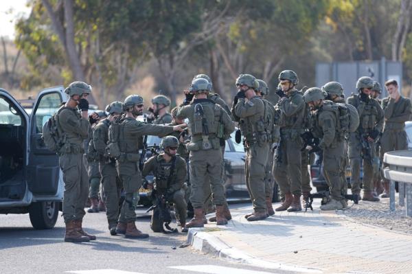Israeli soldiers gather on the road after Palestinian militants infiltrated part of the Gaza Strip.