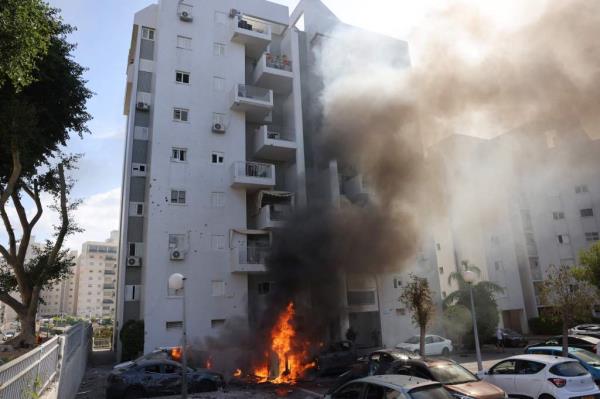 Cars parked outside a residential building catch fire during a rocket attack from the Gaza Strip in Ashkelon.