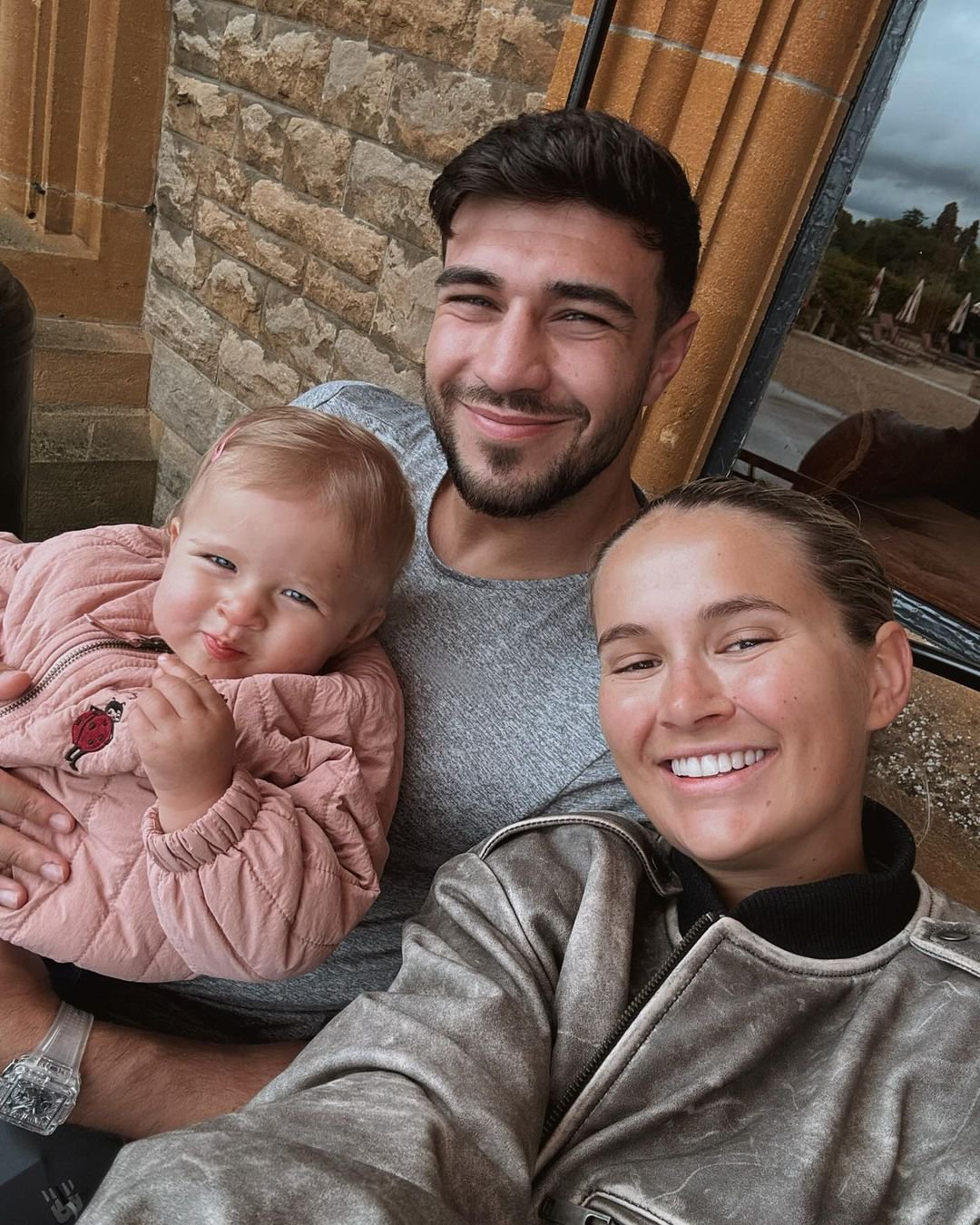 Molly Mae and Tommy Fury smile for a selfie as they pose with their young daughter