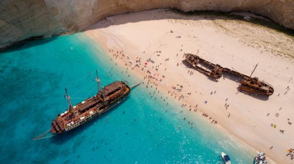 Beached shipwrecks surrounded by tourists