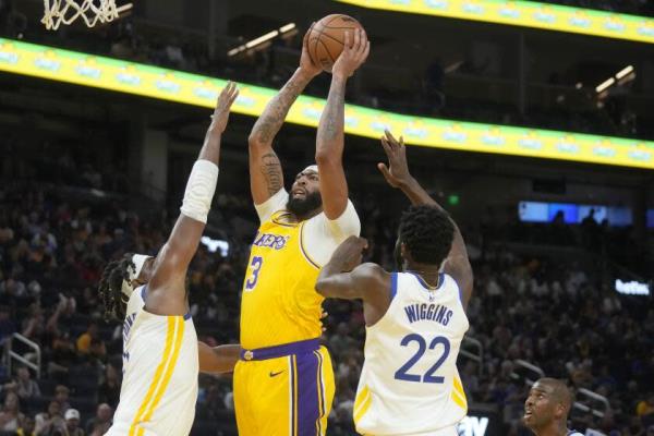 洛杉矶湖人队前锋安东尼·戴维斯（3号）在旧金山进行的一场NBA季前赛中，对阵金州勇士队前锋凯文·鲁尼（左）和安德鲁·威金斯（22号）进行投篮。比赛于2023年10月7日星期六举行。（美联社照片/杰夫·丘）