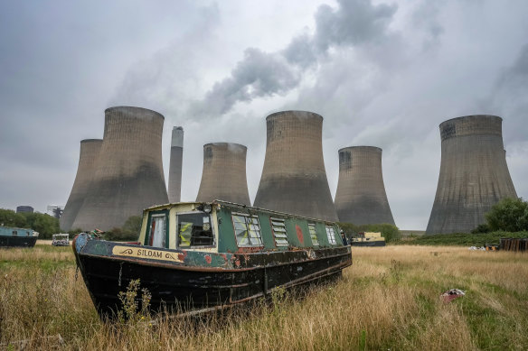 Narrow boats waiting for renovation stand in a marina yard next to the eight giant cooling towers of Ratcliffe-on-Soar power station in Nottinghamshire. The power station, operated by German-owned Uniper, is the last coal-fired station in the UK. 