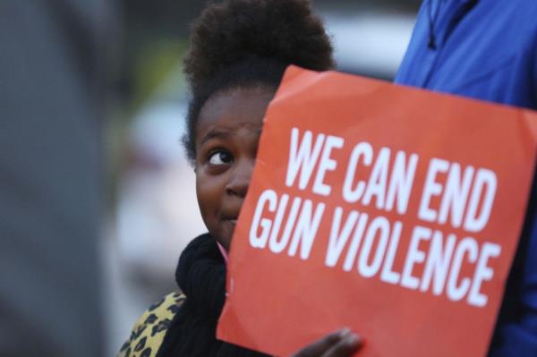 A girl holding a sign at a 2018 rally organized by Good Kids Mad City to bring attention to gun violence in Chicago