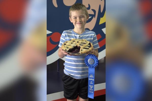 Allen Gage of Mabank, Texas, took home the title after submitting his blueberry pie for judging holding pie and ribbon