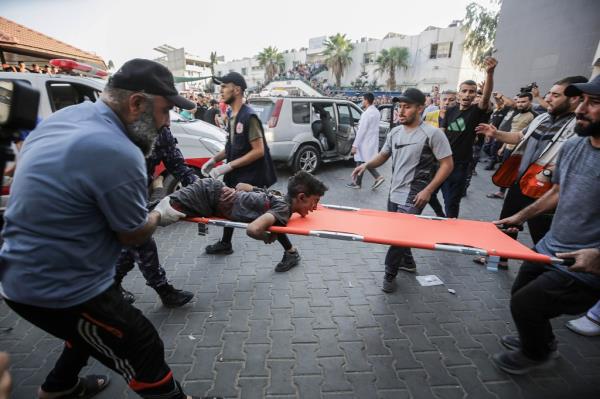 A photo of an injured child being rushed to the hospital in Gaza.