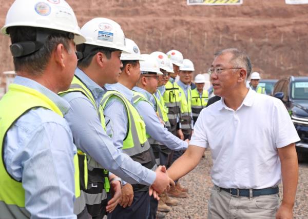 现代汽车董事长郑义宣与沙特阿拉伯Neom市建设现场的现代建设工人握手