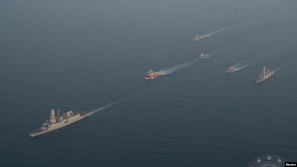 Military vessels escort tugboats as they sail toward the damaged oil tanker Sounion, which has been on fire since Aug. 23, after an attack by Houthi militants, on the Red Sea, Sept. 14, 2024. (Eunavfor Aspides via Reuters)