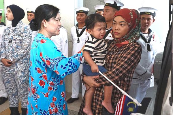 Family torn: Norazliana (right) waiting to claim her husband’s body at Hospital Sultan Ismail in Johor Baru.— THOMAS YONG/The Star