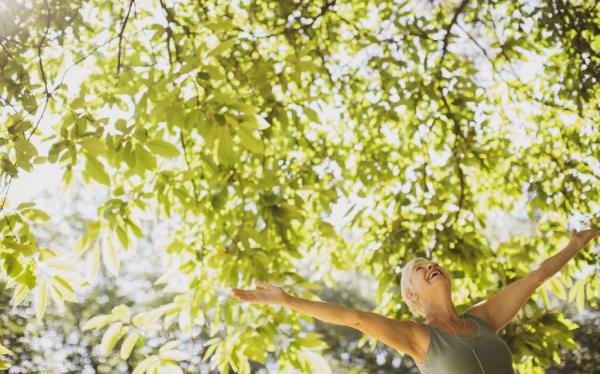 Exuberant senior woman with arms outstretched under sunny tree. (Photo by CAIA IMAGE/SCIENCE PHOTO LIBRARY / NEW / Science Photo Library via AFP)