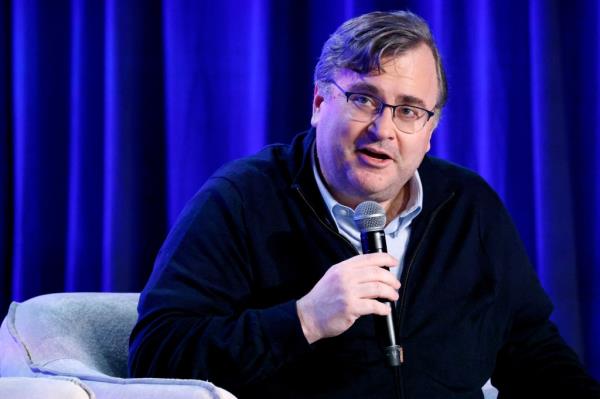 Reid Hoffman speaking onstage with a microphone during The AI Optimist Club at WIRED's 30th Anniversary LiveWIRED event in San Francisco, California.
