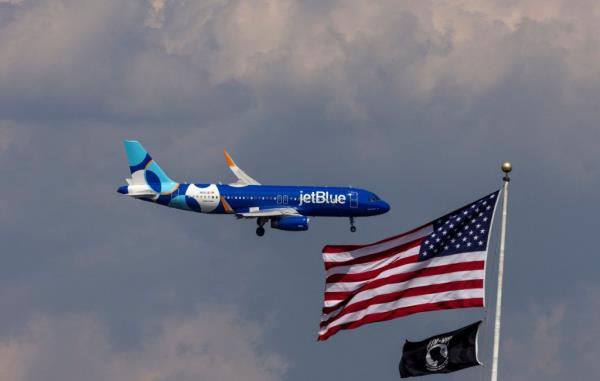 JetBlue Airlines commercial aircraft flying over Washington, approaching for landing at Dulles International Airport.