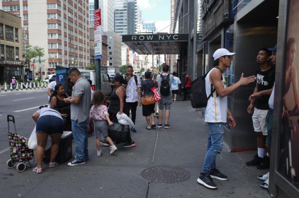 Migrants gathered outside the shelter at the Row NYC Hotel in Manhattan on Aug. 13, 2024.