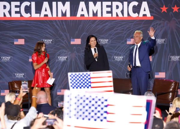 Danica Patrick introducing Tulsi Gabbard and Robert F. Kennedy Jr. at the Reclaim America Tour event with flags in the background