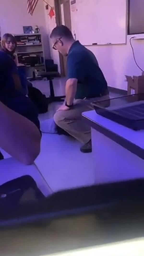 这位教育工作者在示威期间跪在他的一名学生背上。