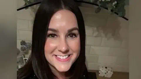 Sourced from X Lucy Connolly, who has dark, shoulder length hair is smiling at the camera. She is standing in front of a white tiled wall indoors.