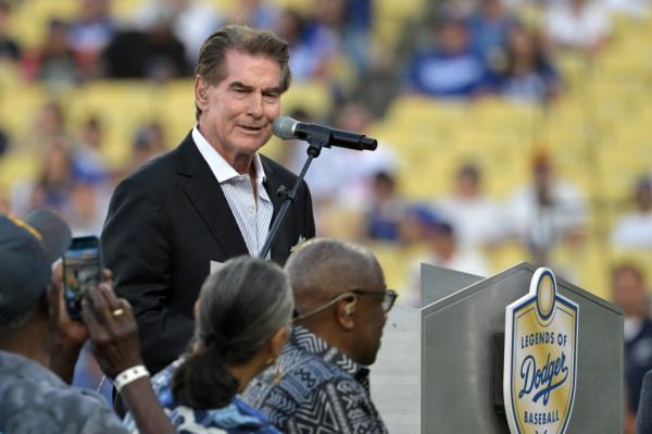 Steve Garvey, former MLB player, speaking into a microphone during a ceremony inducting Dusty Baker into the Dodgers Hall of Legends before a game at Dodger Stadium